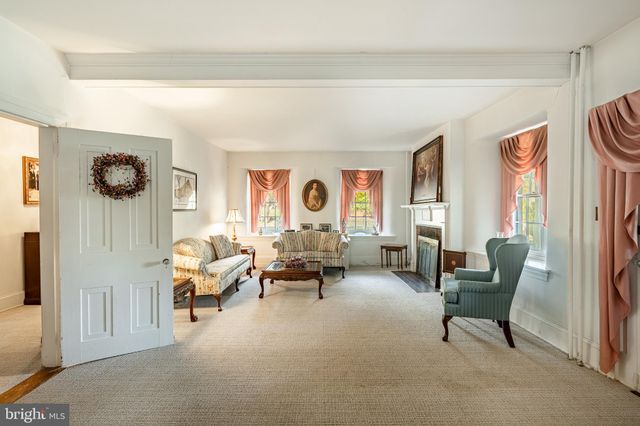 a view of an empty room with a fireplace and chandelier