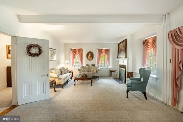a view of an empty room with a fireplace and chandelier