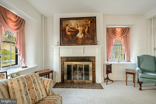 a bedroom with a bed a table and three windows