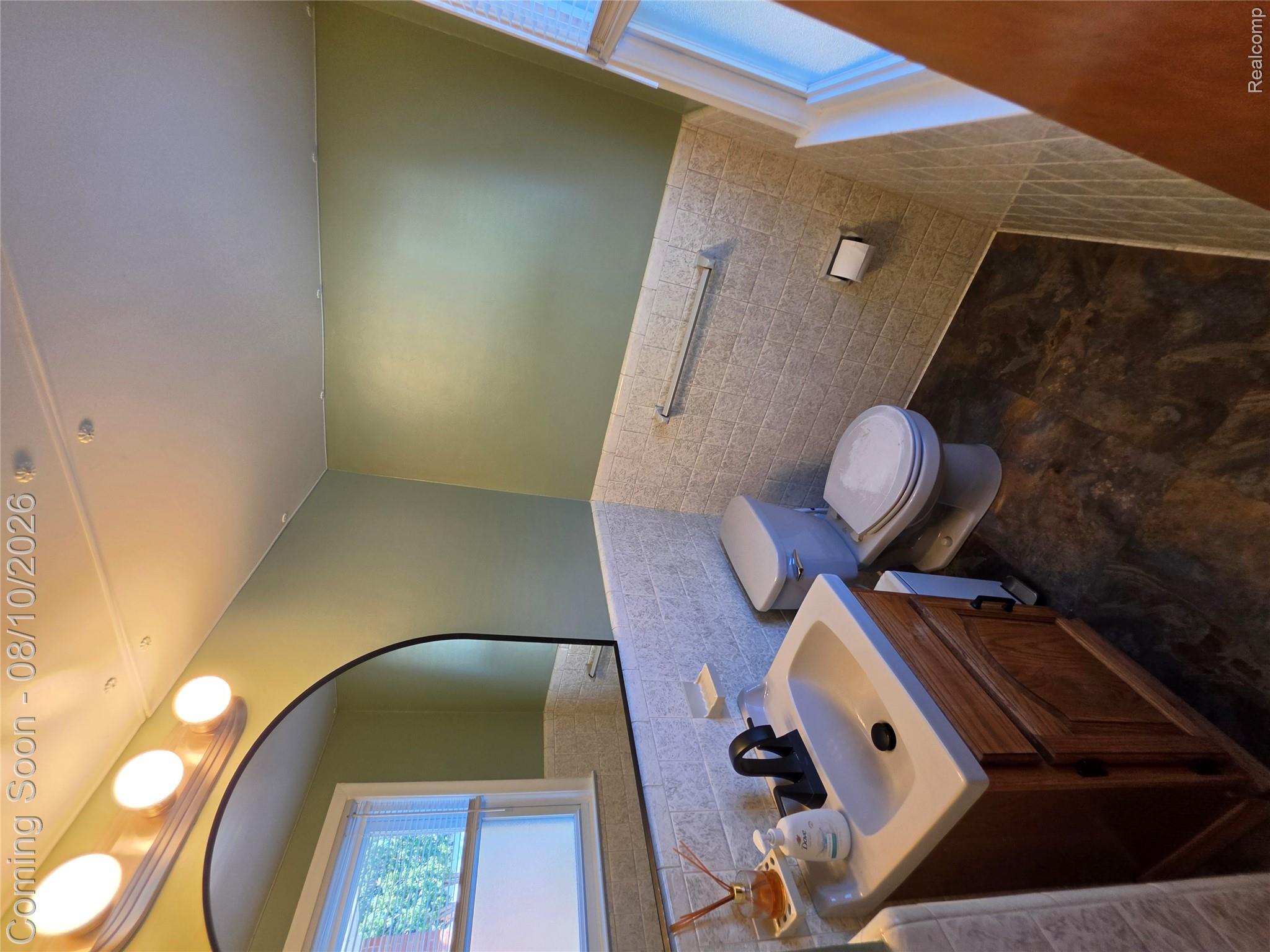 31159 Kelly Road Fraser, MI 48026 - Photo 10 of 13 Freshly updated half bath featuring a wood-finish vanity with an integrated sink, ceramic tile wainscoting, toilet, and recessed lighting