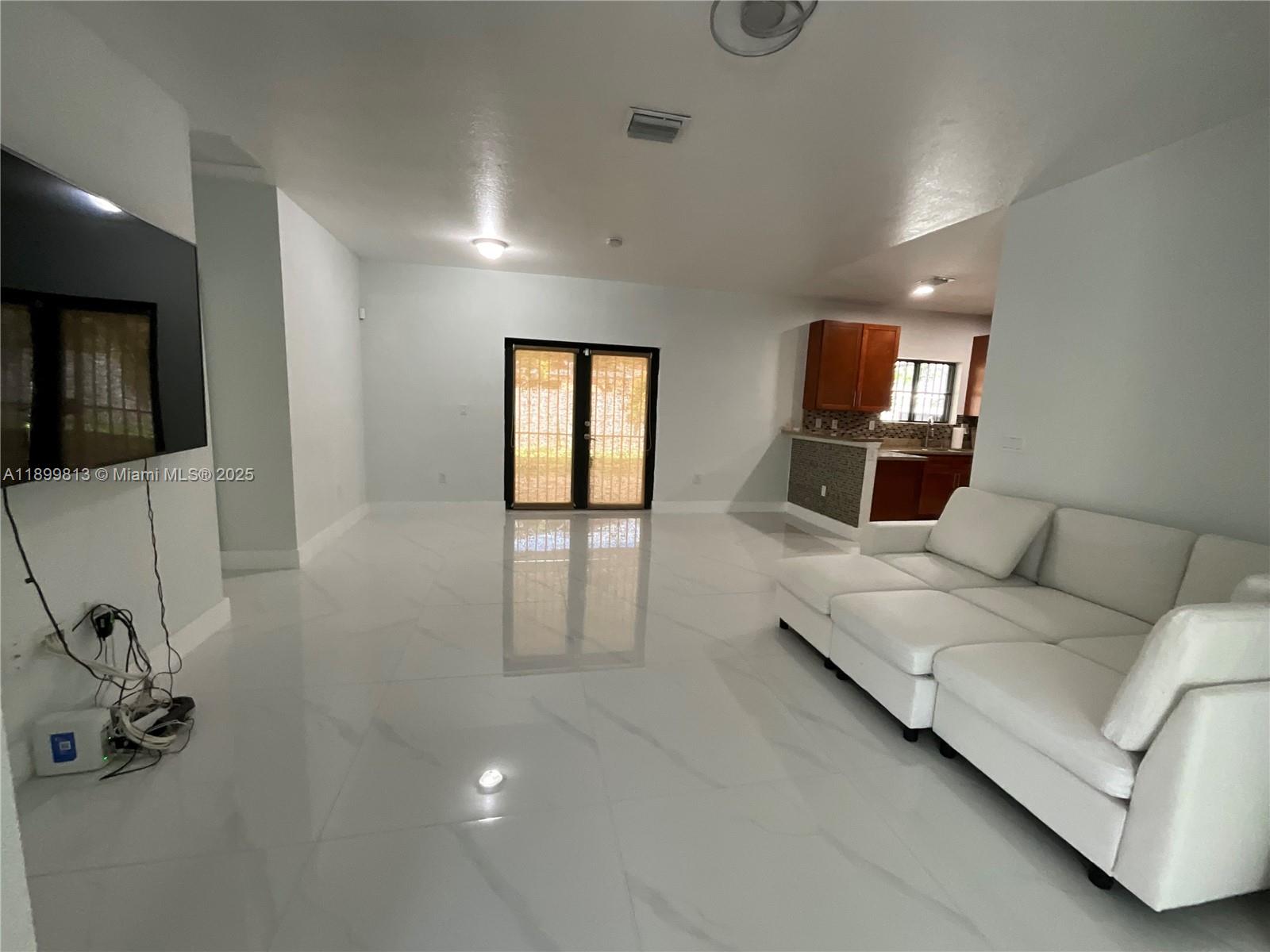 13201 Southwest 274th Terrace Homestead, FL 33032 - Photo 5 of 14 a living room with furniture and a flat screen tv