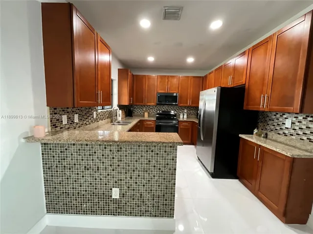 a kitchen with stainless steel appliances a refrigerator and a stove