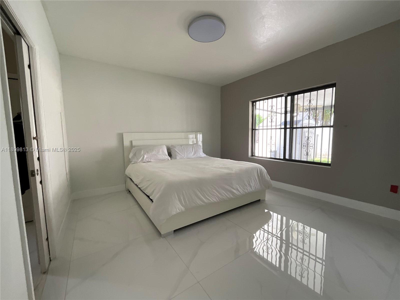 13201 Southwest 274th Terrace Homestead, FL 33032 - Photo 10 of 14 a bedroom with a bed and a window