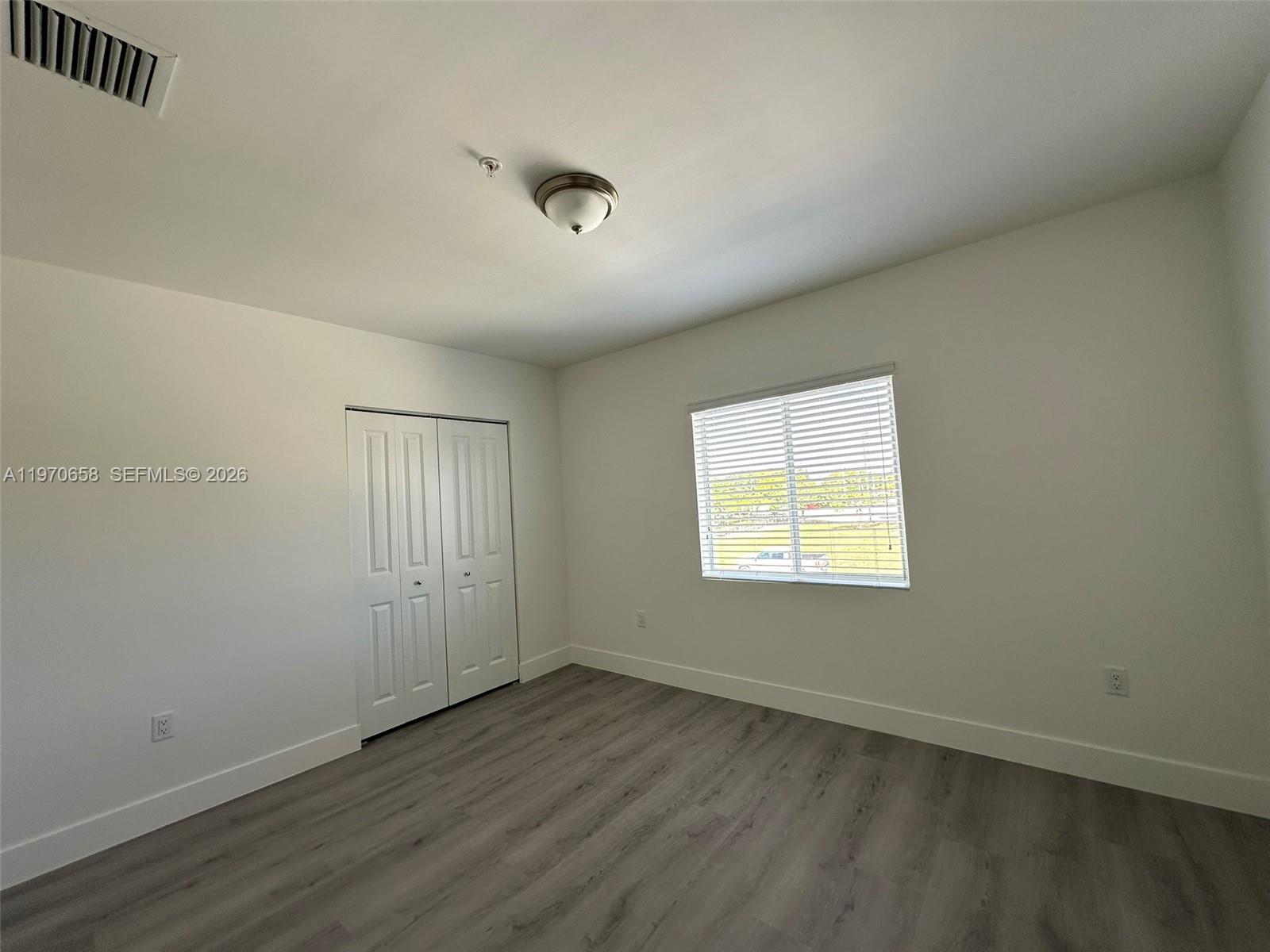 11278 Southwest 187th Street, Unit 11278 Miami, FL 33157 - Photo 12 of 16 an empty room with wooden floor and windows