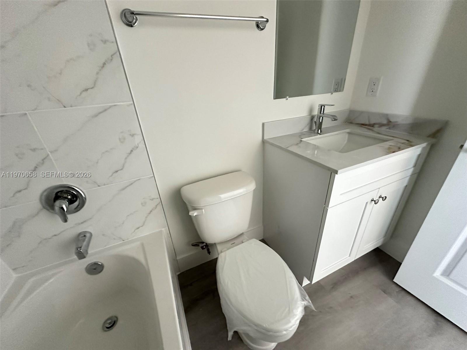11278 Southwest 187th Street, Unit 11278 Miami, FL 33157 - Photo 14 of 16 a bathroom with a granite countertop toilet sink and mirror
