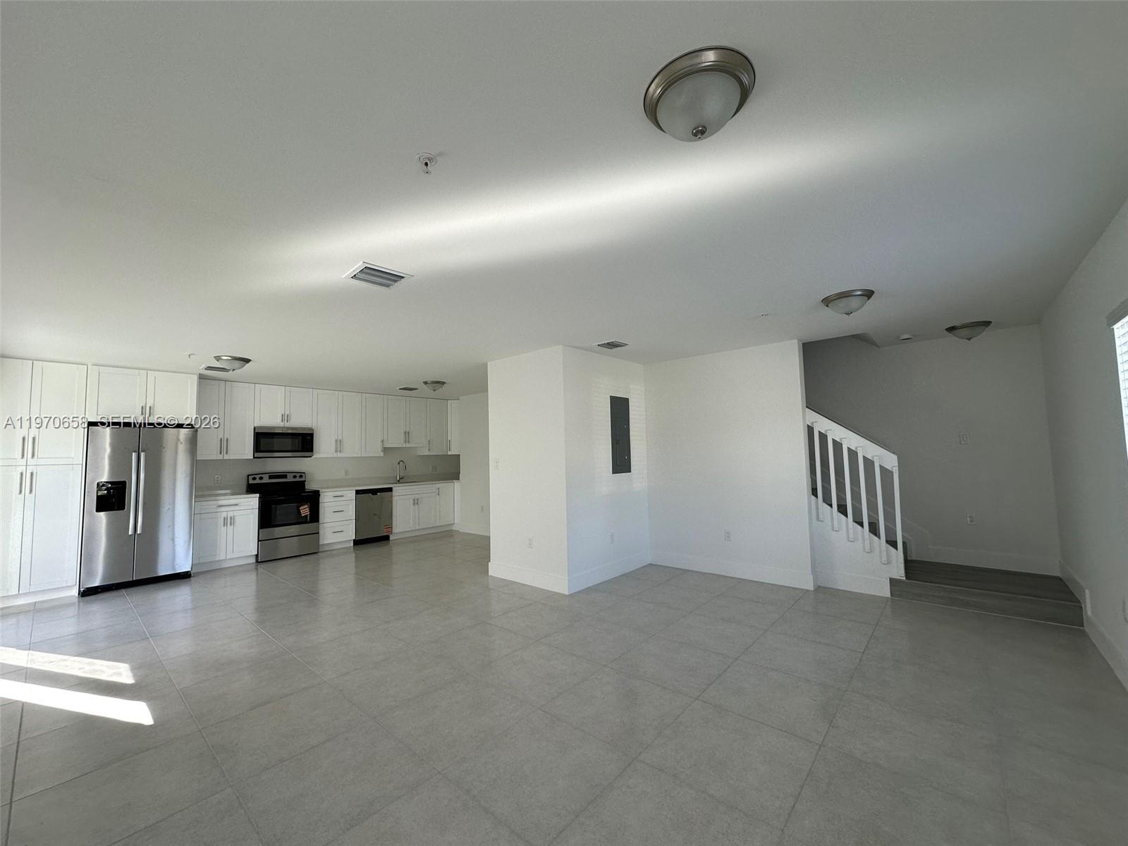 11278 Southwest 187th Street, Unit 11278 Miami, FL 33157 - Photo 3 of 16 a view of a livingroom with kitchen and staircase