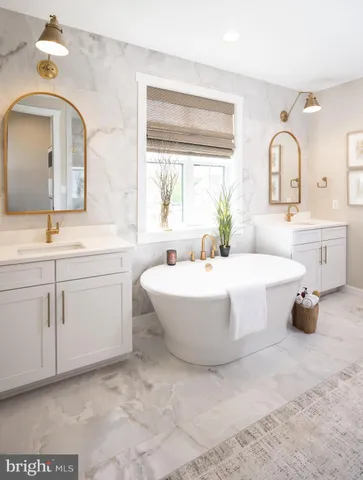 a spacious bathroom with a double vanity sink mirror and bathtub