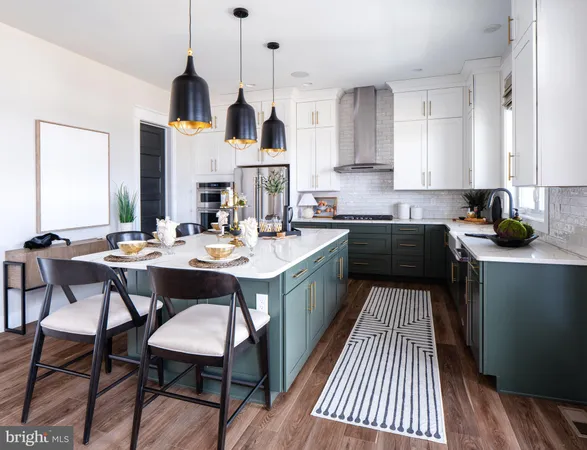 a kitchen with a sink dishwasher a stove a dining table and chairs with wooden floor
