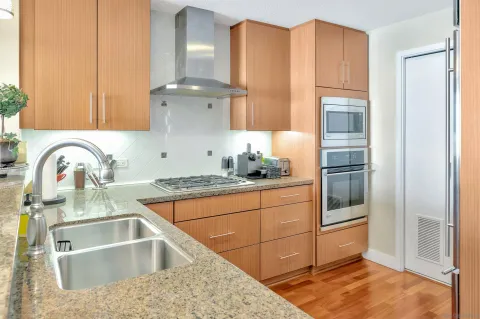 a kitchen with stainless steel appliances granite countertop a sink stove and refrigerator