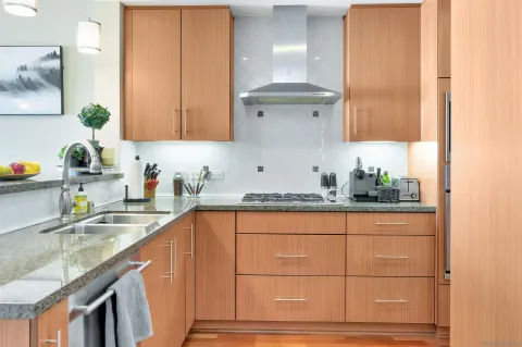a kitchen with granite countertop a sink a stove and cabinets
