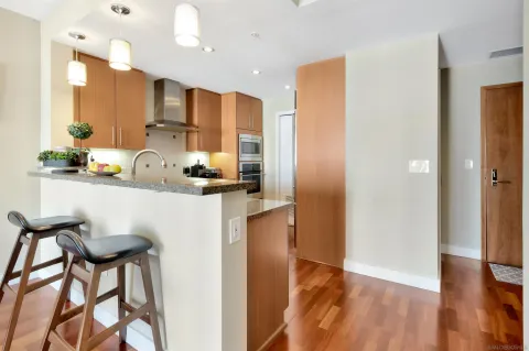 a kitchen with kitchen island granite countertop a refrigerator and a sink