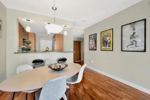 a kitchen with stainless steel appliances granite countertop a dining table and chairs with wooden floor
