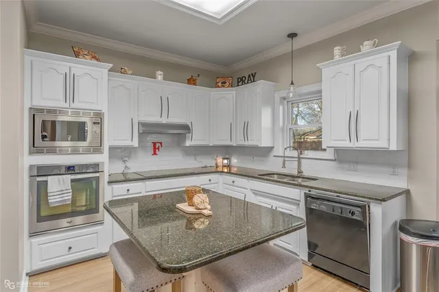 a kitchen with stainless steel appliances granite countertop a sink stove and refrigerator