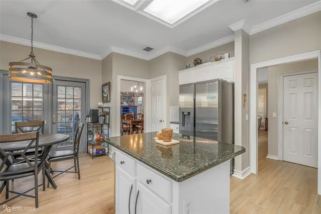 a kitchen with granite countertop kitchen island stainless steel appliances a table and chairs