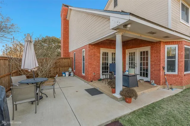 a view of backyard with table and chairs and wooden fence