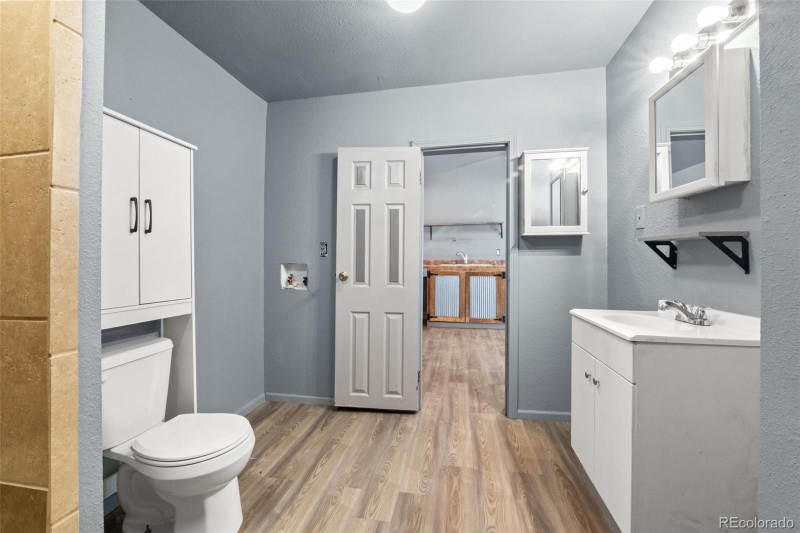 620 Hospital Road Brush, CO 80723 - Photo 21 of 24 a bathroom with a toilet sink and mirror