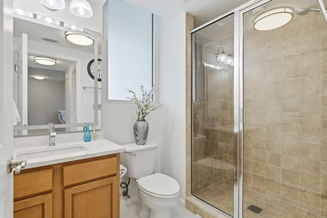 a bathroom with a sink a toilet and shower