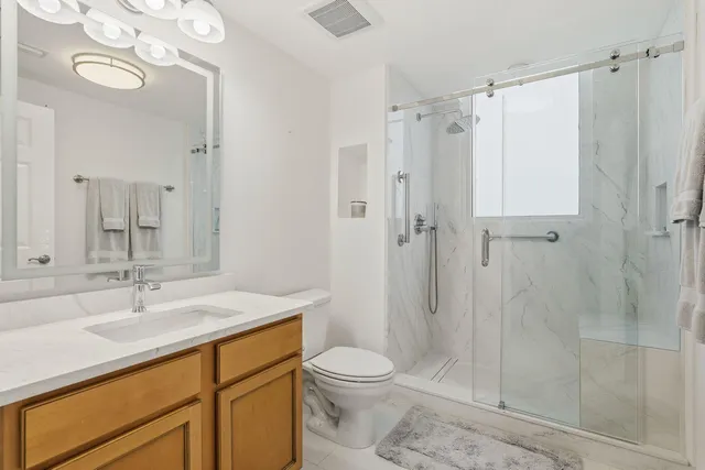 a bathroom with a sink a toilet and shower