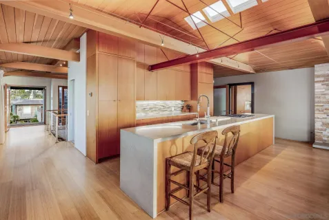 a living room with furniture a flat screen tv and kitchen view