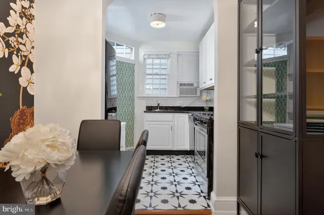 a kitchen with stainless steel appliances granite countertop white cabinets and black stove top oven with granite countertops
