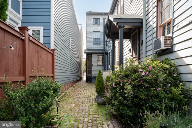 a view of patio with a table and chairs under an umbrella with a barbeque