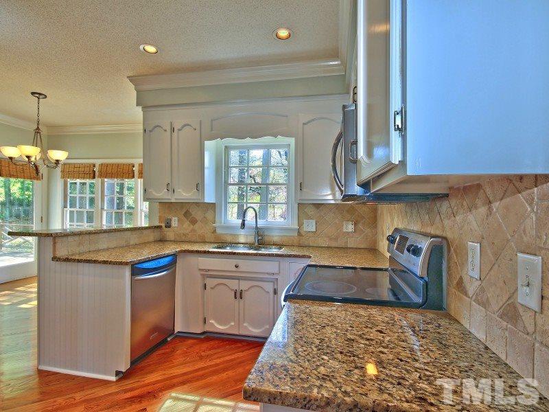 8004 Laurel Mountain Road Raleigh, NC 27613 - Photo 7 of 25 a kitchen with a sink a counter top space and cabinets