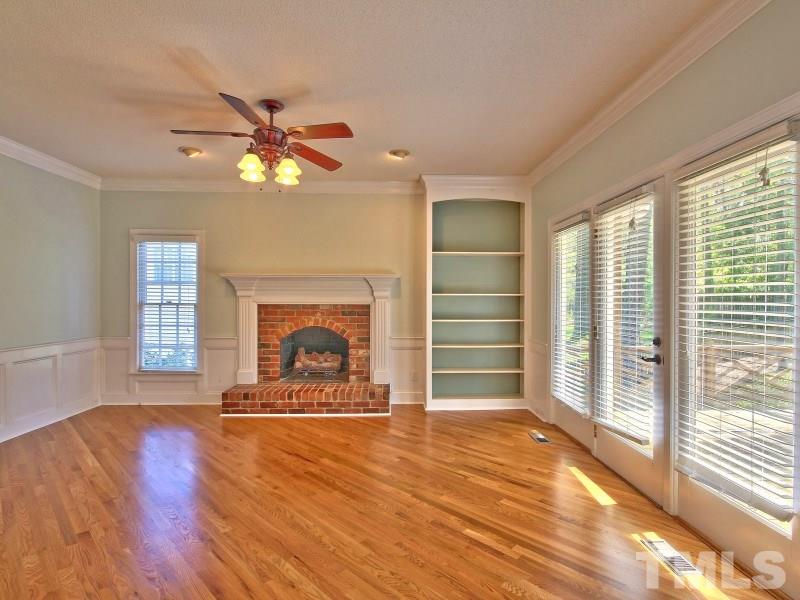 8004 Laurel Mountain Road Raleigh, NC 27613 - Photo 10 of 25 a view of a livingroom with a fireplace a ceiling fan and windows
