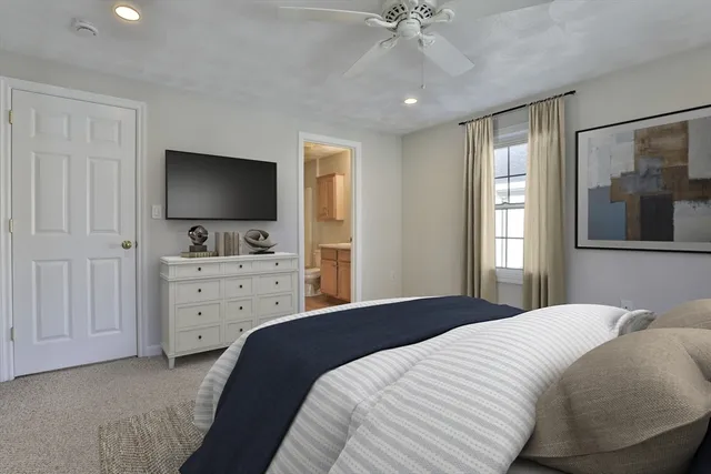 a bedroom with a bed and a flat tv screen on dresser