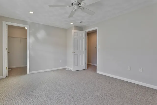 an empty room with a ceiling fan and closet area