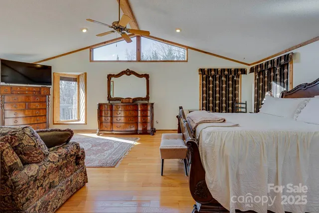 a bedroom with furniture large window and wooden floor