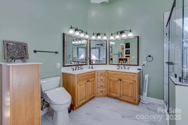 a bathroom with a double vanity sink mirror and toilet