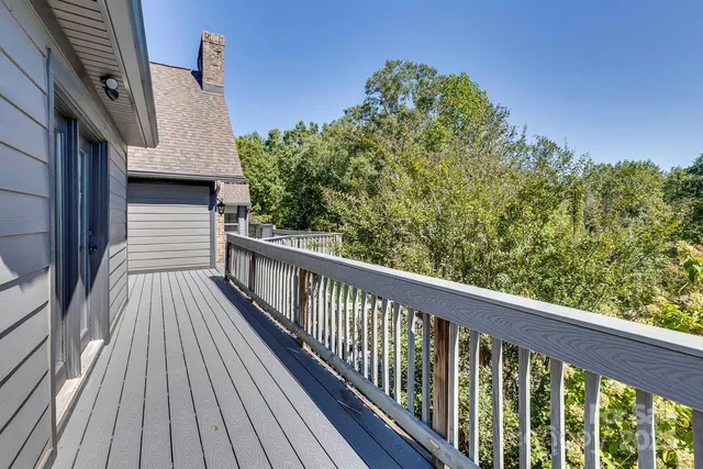 a view of a balcony with wooden floor and fence