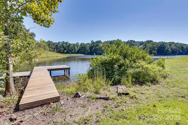 a wooden pier with boats in the background