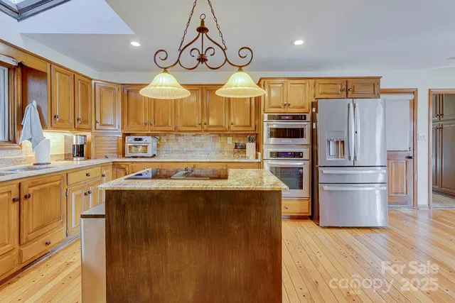 a kitchen with stainless steel appliances a stove refrigerator and a sink
