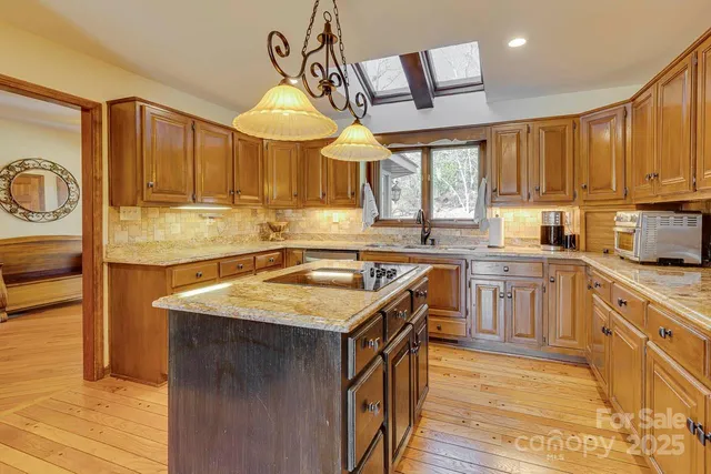 a kitchen with stainless steel appliances granite countertop a sink a stove and a refrigerator