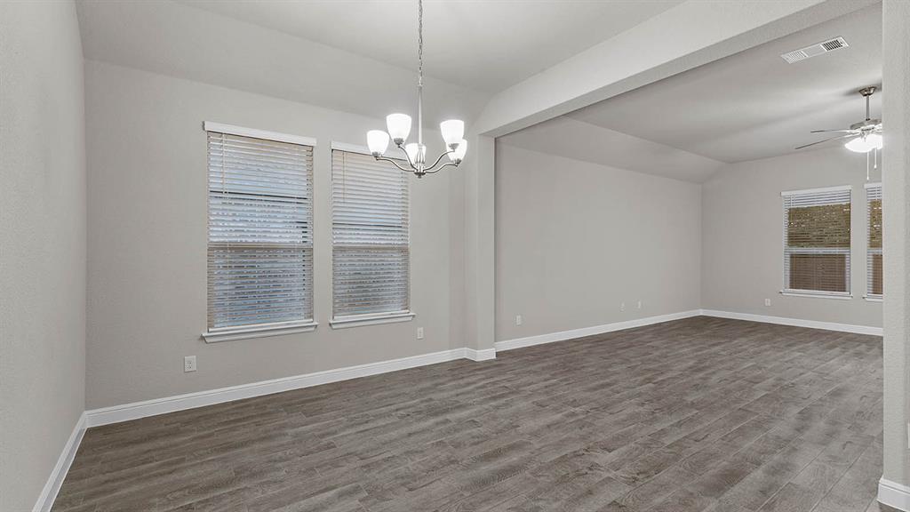 3275 Grayton Street Grand Prairie, TX 76065 - Photo 14 of 36 an empty room with wooden floor chandelier and windows