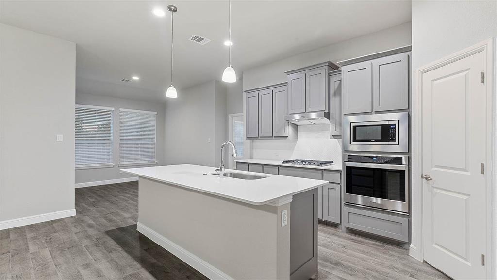 3275 Grayton Street Grand Prairie, TX 76065 - Photo 3 of 36 a kitchen with a sink stainless steel appliances and cabinets