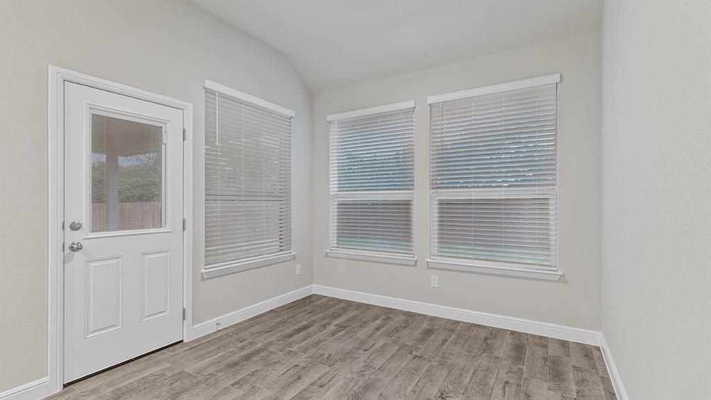 3275 Grayton Street Grand Prairie, TX 76065 - Photo 7 of 36 a view of an empty room with wooden floor and a window