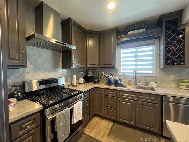 a kitchen with stainless steel appliances a sink stove and cabinets