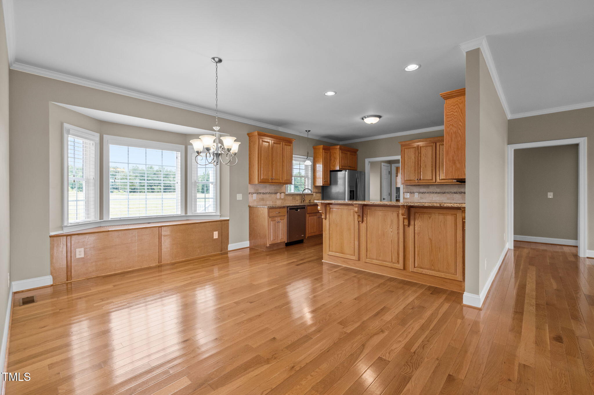 5556 Hurdle Mills Road Roxboro, NC 27574 - Photo 17 of 53 a view of a kitchen with a stove wooden cabinets and a living room