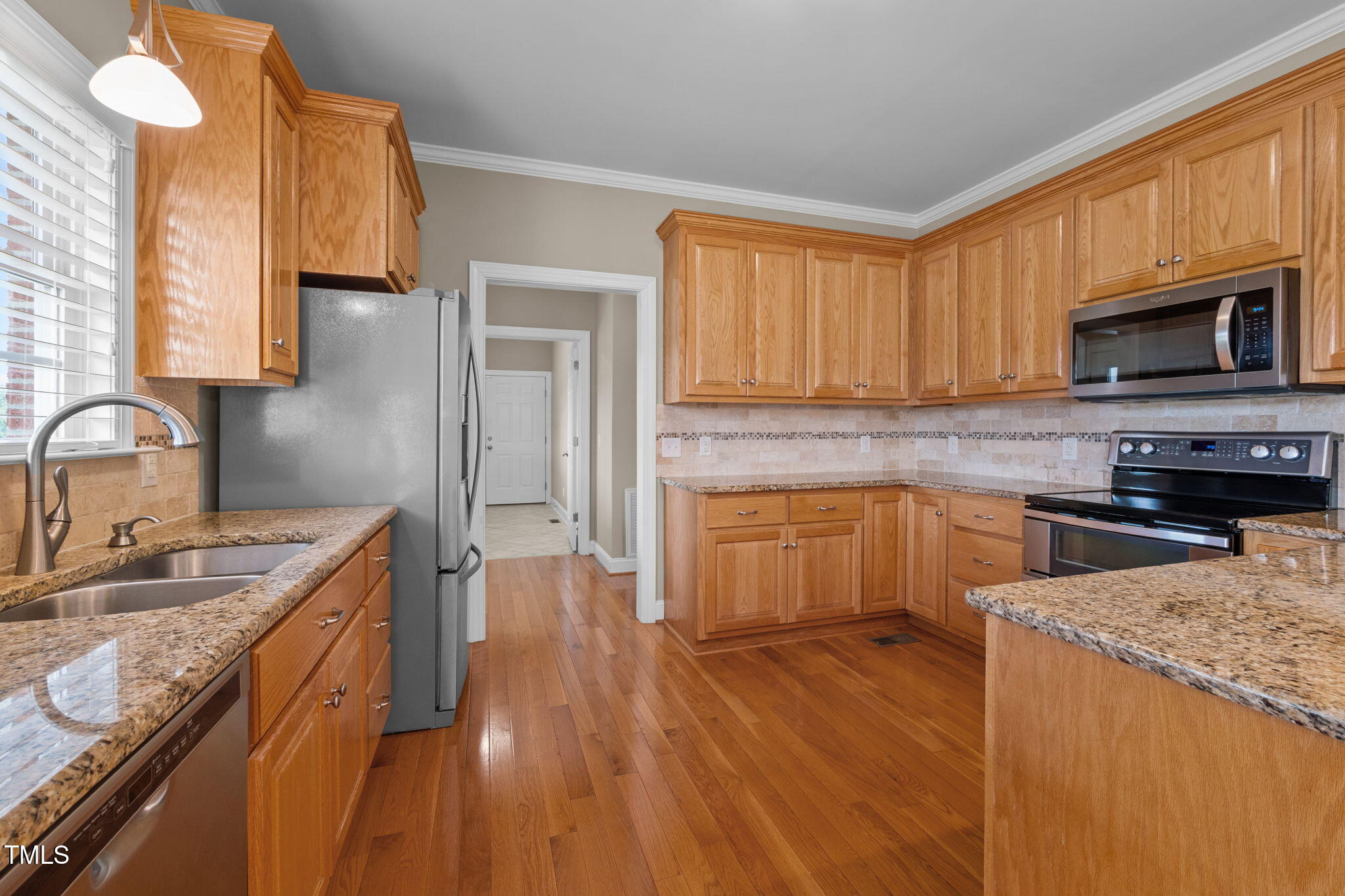 5556 Hurdle Mills Road Roxboro, NC 27574 - Photo 20 of 53 a kitchen with granite countertop wooden floors a sink stainless steel appliances and cabinets