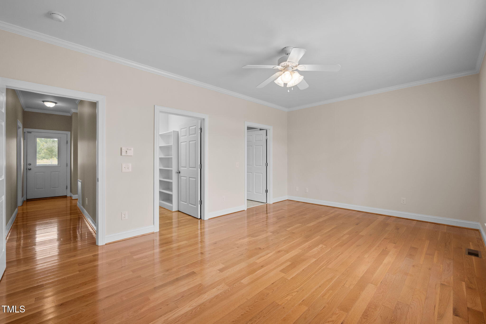 5556 Hurdle Mills Road Roxboro, NC 27574 - Photo 25 of 53 a view of an empty room with wooden floor and a ceiling fan