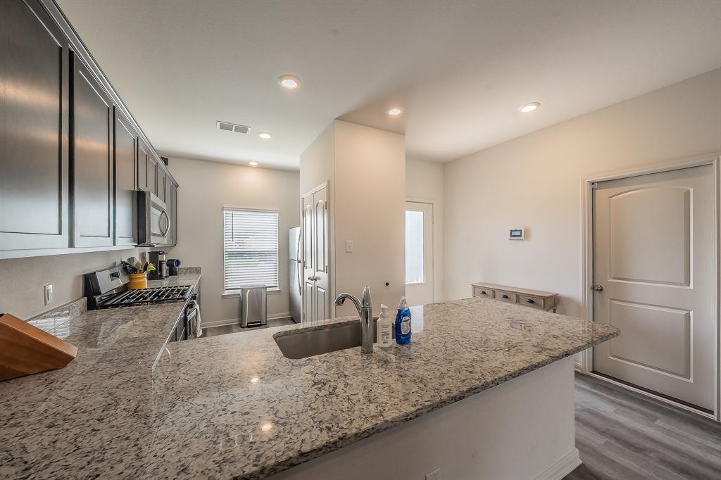 8125 White Sulphur Road Ponder, TX 76259 - Photo 7 of 38 Kitchen featuring a large island with an undermount sink, speckled countertop, and recessed lighting
