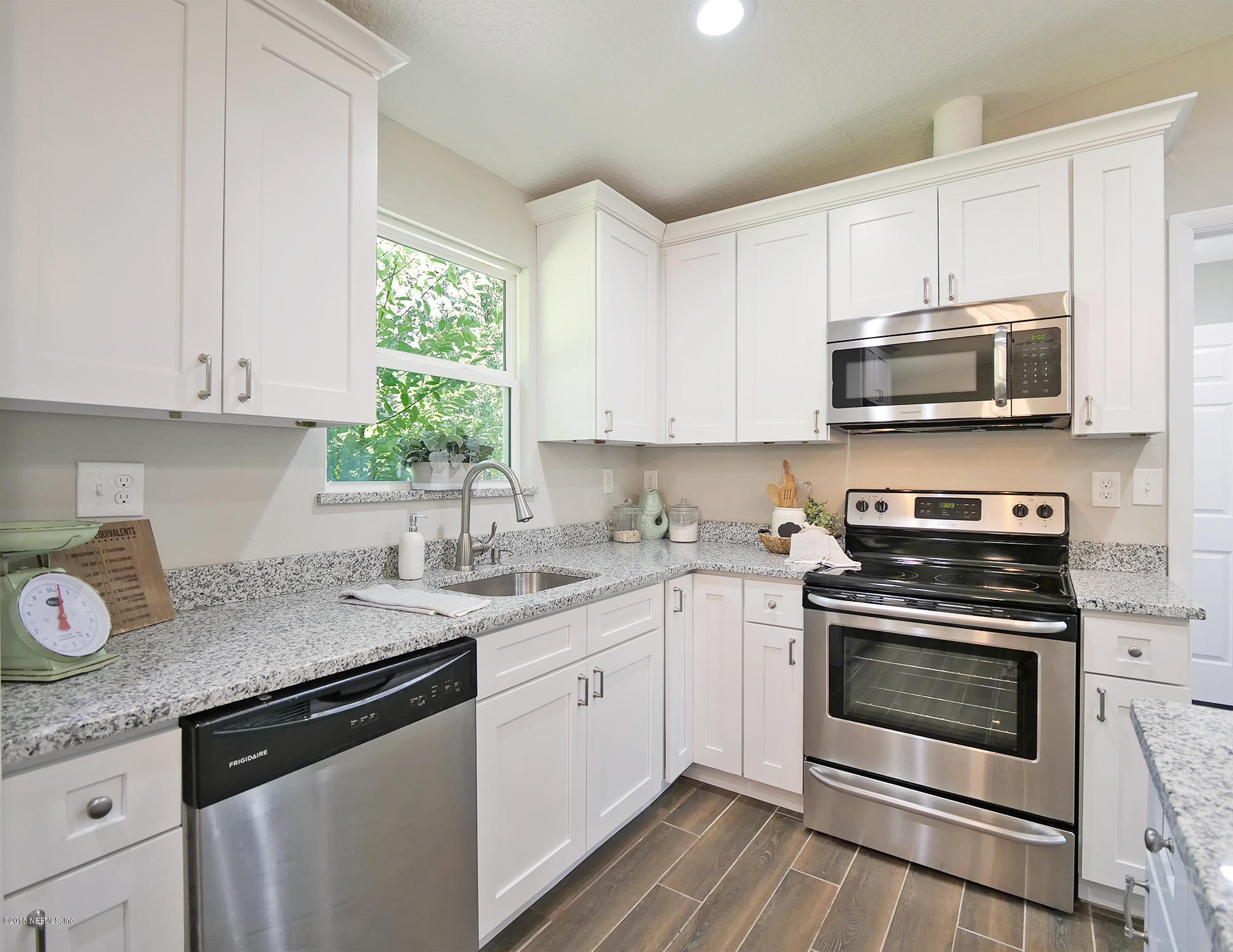 10475 Tulsa Road Jacksonville, FL 32218 - Photo 3 of 30 a kitchen with granite countertop a stove a sink and a microwave