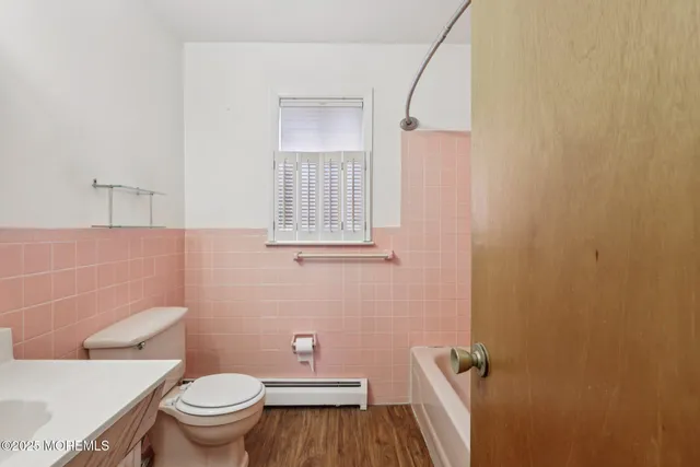 a bathroom with a granite countertop toilet and a sink