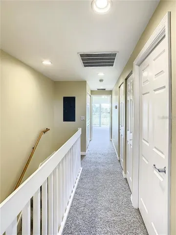 a view of a hallway with wooden floor and windows