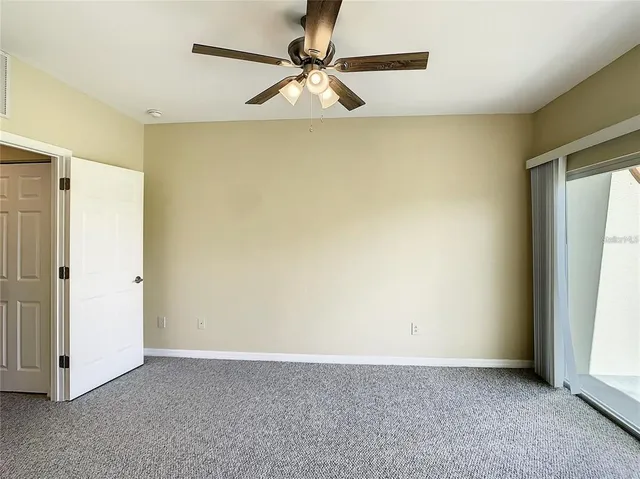 an empty room with a window and a fan