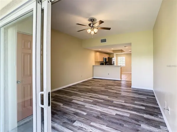 a view of a livingroom with wooden floor and a ceiling fan