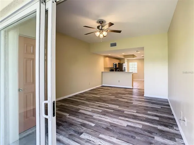 a view of a livingroom with wooden floor and a ceiling fan