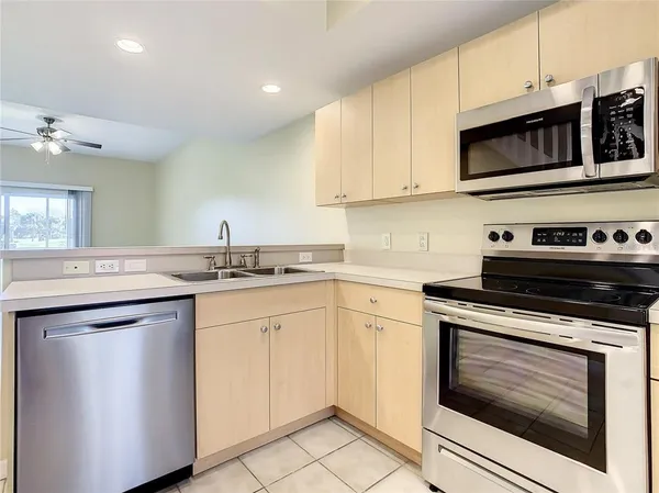 a kitchen with stainless steel appliances granite countertop a stove microwave and sink